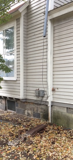 Photo of downspout sticking out at an angle from the building.